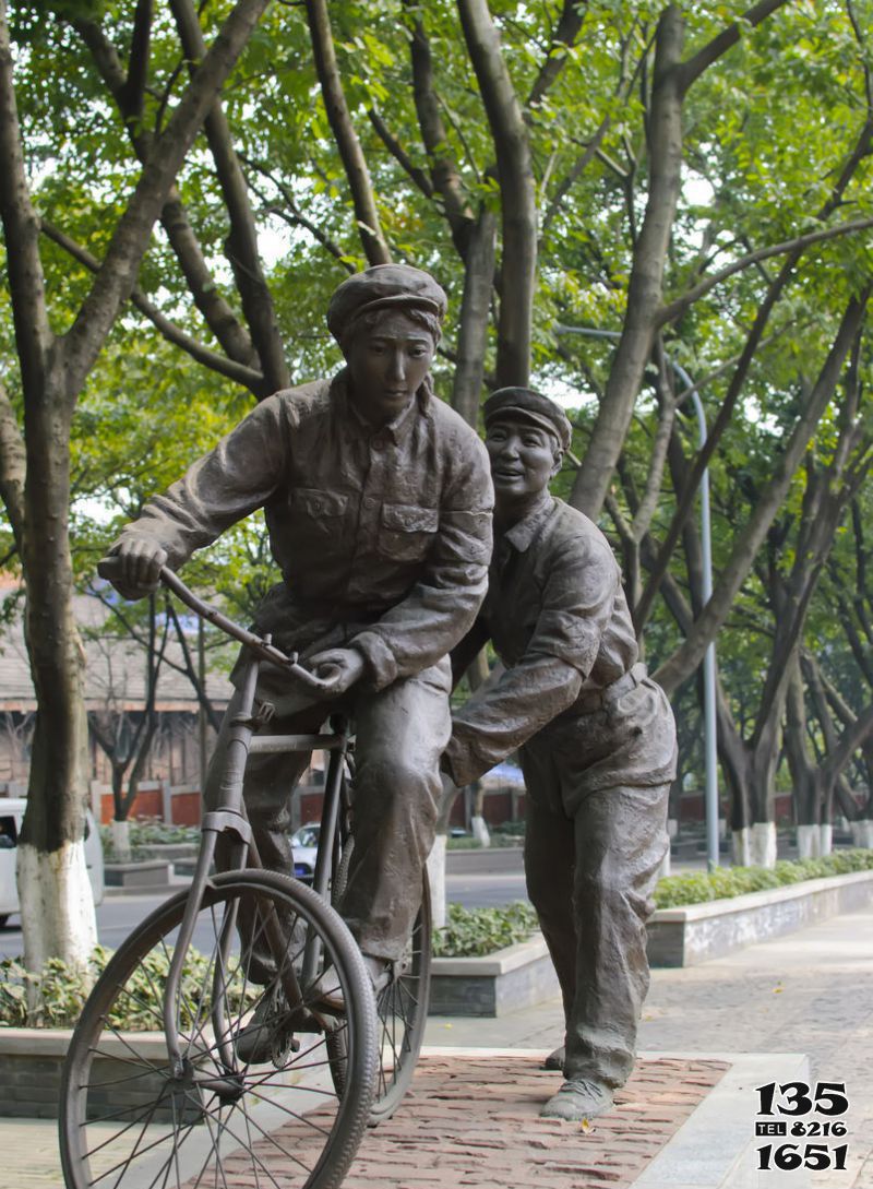 自行車雕塑-公園學騎自行車的人物銅雕高清圖片